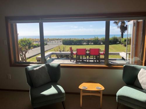 a room with a window with a view of a patio at Kanuka Ridge Lodge in Marahau