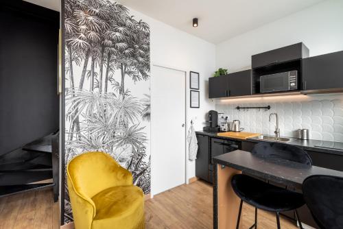 a kitchen with a yellow chair next to a counter at Le Cocon Des Artistes in Lyon