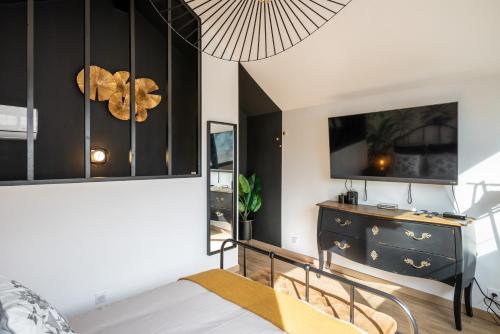 a bedroom with a bed and a dresser at Le Cocon Des Artistes in Lyon