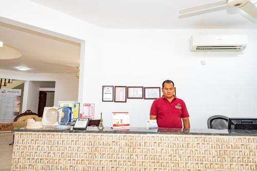 a man standing behind a counter in a kitchen at Oriental Nights Rest House in Al Wāşil