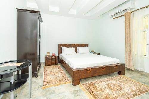 a bedroom with a bed and a glass table at Oriental Nights Rest House in Al Wāşil