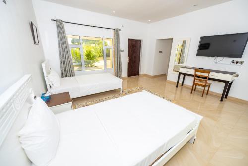a large white room with a bed and a desk at Oriental Nights Rest House in Al Wāşil