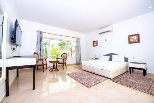 a bedroom with a bed and a desk and a piano at Oriental Nights Rest House in Al Wāşil