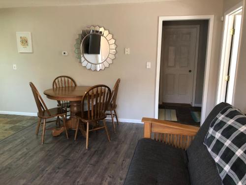 a living room with a table and chairs and a mirror at Burrel Avenue Apartments in Cooperstown