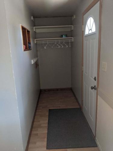 a hallway with a closet and a door with a rug at Burrel Avenue Apartments in Cooperstown