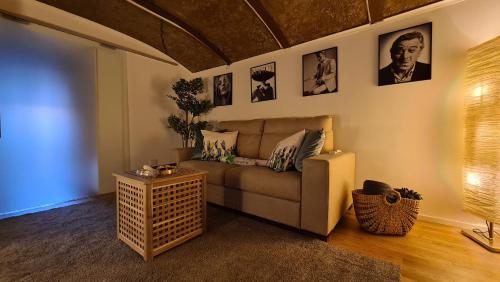 a living room with a couch and pictures on the wall at La Foresteria in Caserta