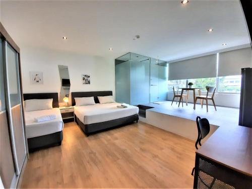 a bedroom with two beds and a dining room with a table at International Service Apartments at Raeburn Park in Singapore