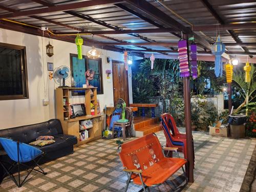 a living room with a couch and chairs at Bunrapee House in Nan