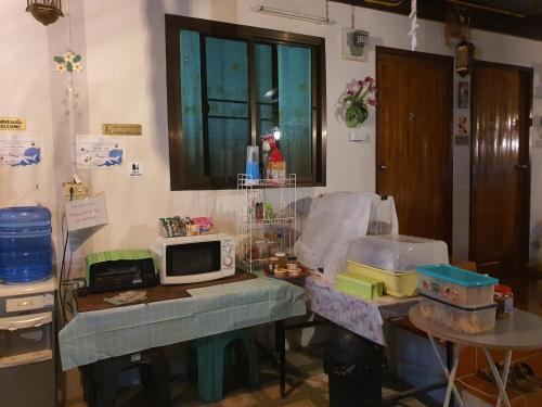 a room with a table with a microwave on it at Bunrapee House in Nan