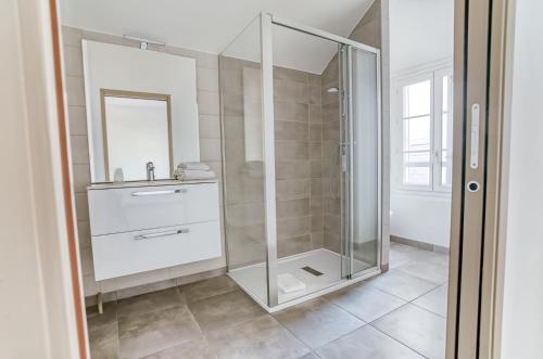 a bathroom with a glass shower and a sink at Brit Hotel Bristol Montbéliard Centre in Montbéliard