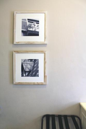 two framed photographs on a wall next to a chair at Colmar Tropicale in Bukit Tinggi