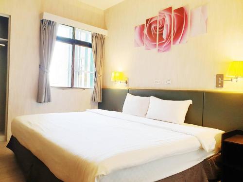 a bedroom with a large white bed with a window at Walker Hotel - Sanchong in Taipei