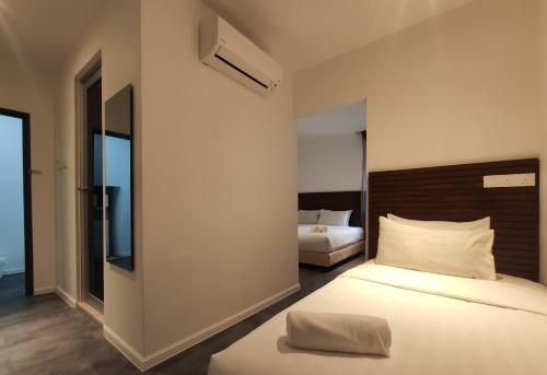 a bedroom with two beds and a mirror at T Hotel Tandop in Alor Setar