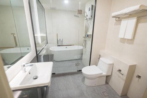 a white bathroom with a sink and a toilet at Siri regent Hotel in Nakhon Phanom