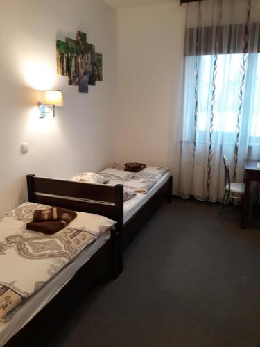 two beds in a small room with a window at Astra Apartments in Oświęcim