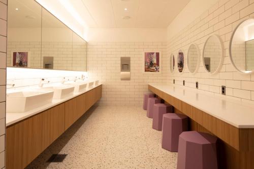 a bathroom with sinks and mirrors and purple stools at Sangsang Stay Busan in Busan