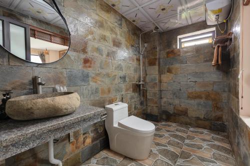 W łazience znajduje się umywalka, toaleta i lustro. w obiekcie Mega View Homestay w mieście Sa Pa