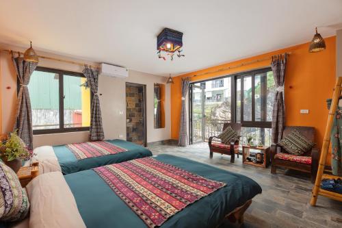 a bedroom with two beds in a room with orange walls at Mega View Homestay in Sa Pa