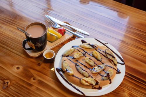 a table with a plate of pancakes and a cup of coffee at Mega View Homestay in Sa Pa