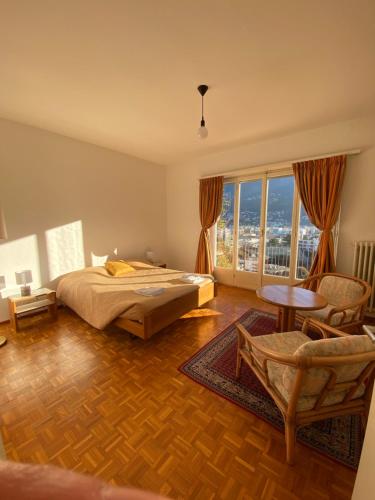 1 dormitorio con cama y ventana grande en Cube 3A Flat, en Lugano
