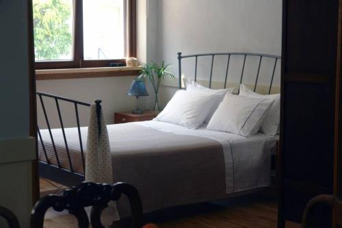 um quarto com uma cama com lençóis brancos e almofadas em Unique - Spacious Studio with rooftop / Thissio em Atenas