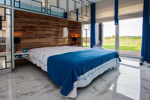 a bedroom with a large bed with a wooden wall at GOLF APARTAMENT W Sobieniach in Sobienie Jeziory