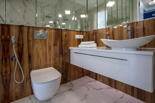 uma casa de banho com um WC, um lavatório e um espelho. em GOLF APARTAMENT W Sobieniach em Sobienie Jeziory