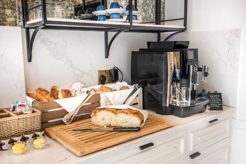 a kitchen with a counter with bread and a coffee maker at The Capital Hotel, Apartments & Townhouse - Small Luxury Hotels of The World in London