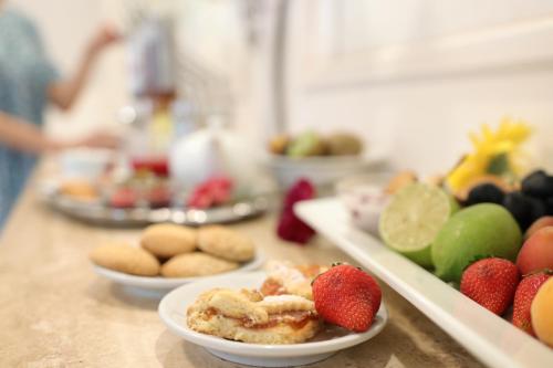 a table with plates of food on a counter with fruit at Hotel Castel Miramonti in Selva di Fasano