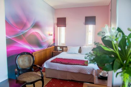 a bedroom with a bed and a table and a chair at Hotel Apollo in Darłówko