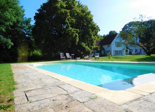 - une piscine en face d'une maison dans l'établissement B&B Domein Rodin, à Oud-Turnhout