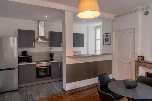 une cuisine et un salon avec une table et des chaises dans l'établissement Suite Ophélie, à Charleville-Mézières