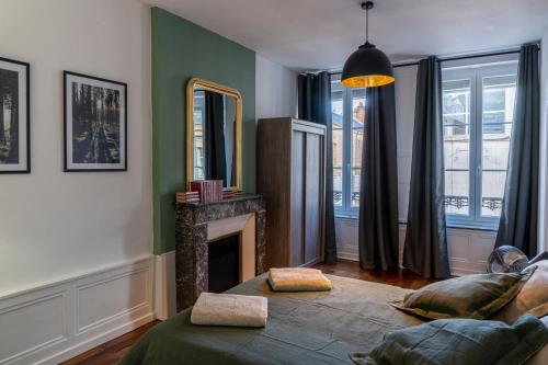 un salon avec une cheminée et un miroir dans l'établissement Suite Ophélie, à Charleville-Mézières