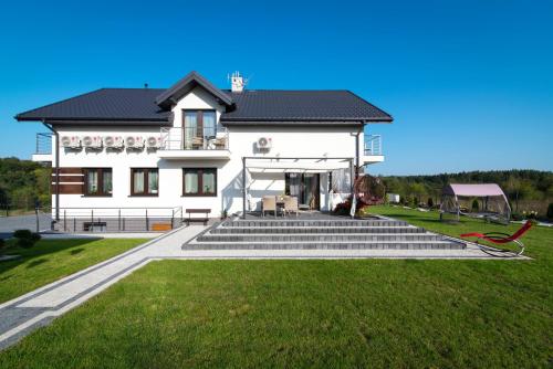 a large white house with stairs in front of it at Za Gościńcem in Kazimierz Dolny