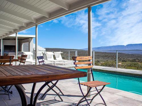 a patio with a table and chairs and a pool at Rooiberg Wild Private Game Reserve in Ladismith