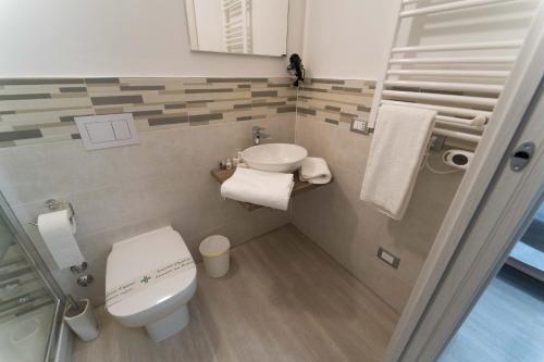 a small bathroom with a toilet and a sink at Claudio Rooms in Fabbrico