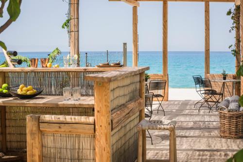 a table on a deck with the ocean in the background at F ZEEN Kefalonia in Lourdhata