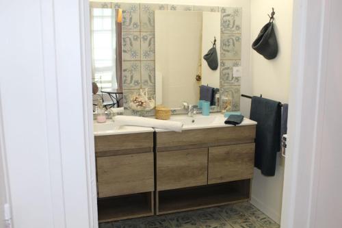 a bathroom with a sink and a mirror at La Porte Ouverte in Saint-Denoual