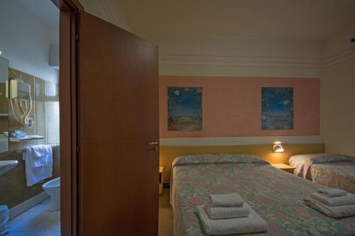 a bedroom with a bed and a table at Hotel Savoia in Finale Ligure