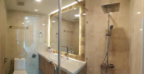 a bathroom with a shower and a sink and a toilet at City Garden Tower Condo by Som in Pattaya South