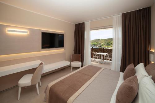 a hotel room with a bed and a television at Hotel La Perla Del Golfo in Procchio
