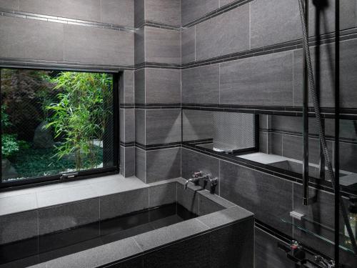 a bathroom with a bath tub and a window at Connect inn Shichijo-Kawaramachi in Kyoto