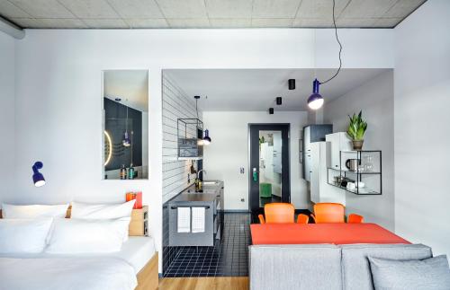 ein Wohnzimmer mit einem Bett und orangefarbenen Stühlen in der Unterkunft STAYERY Bielefeld Hauptbahnhof in Bielefeld