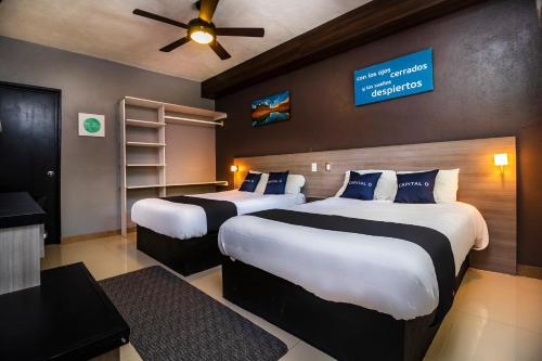 una habitación de hotel con 2 camas y un cartel en la pared en Collection O Hotel Mango,Six Flags Hurricane Harbor Oaxtepec en Oaxtepec