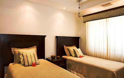 a bedroom with two beds and a window at Casa del Sol -Villas Catalinas in Potrero