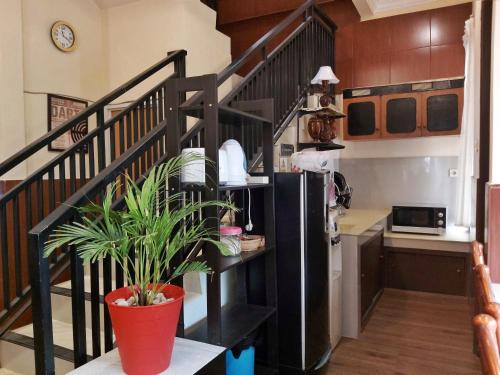 a kitchen with a black staircase with a refrigerator at TAMA Guesthouse 15 People for Family or Group in Tangerang