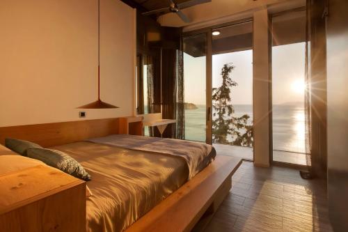 sypialnia z łóżkiem i widokiem na ocean w obiekcie Zen House Crete w mieście Palaiokastro