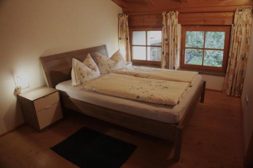 1 dormitorio con 1 cama grande y ventana en Farnreit en Brixen im Thale