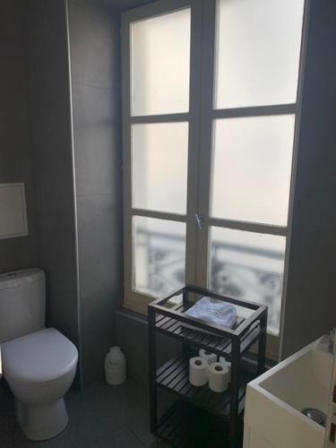 a small bathroom with a toilet and a window at Lovely parisien apartment (opera 3) in Paris