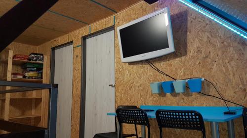 a tv on a wall with a table and chairs at Chata Tanvaldský Špičák in Tanvald